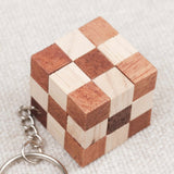 Gros plan du mini cube serpent en bois, motif damier clair et foncé.