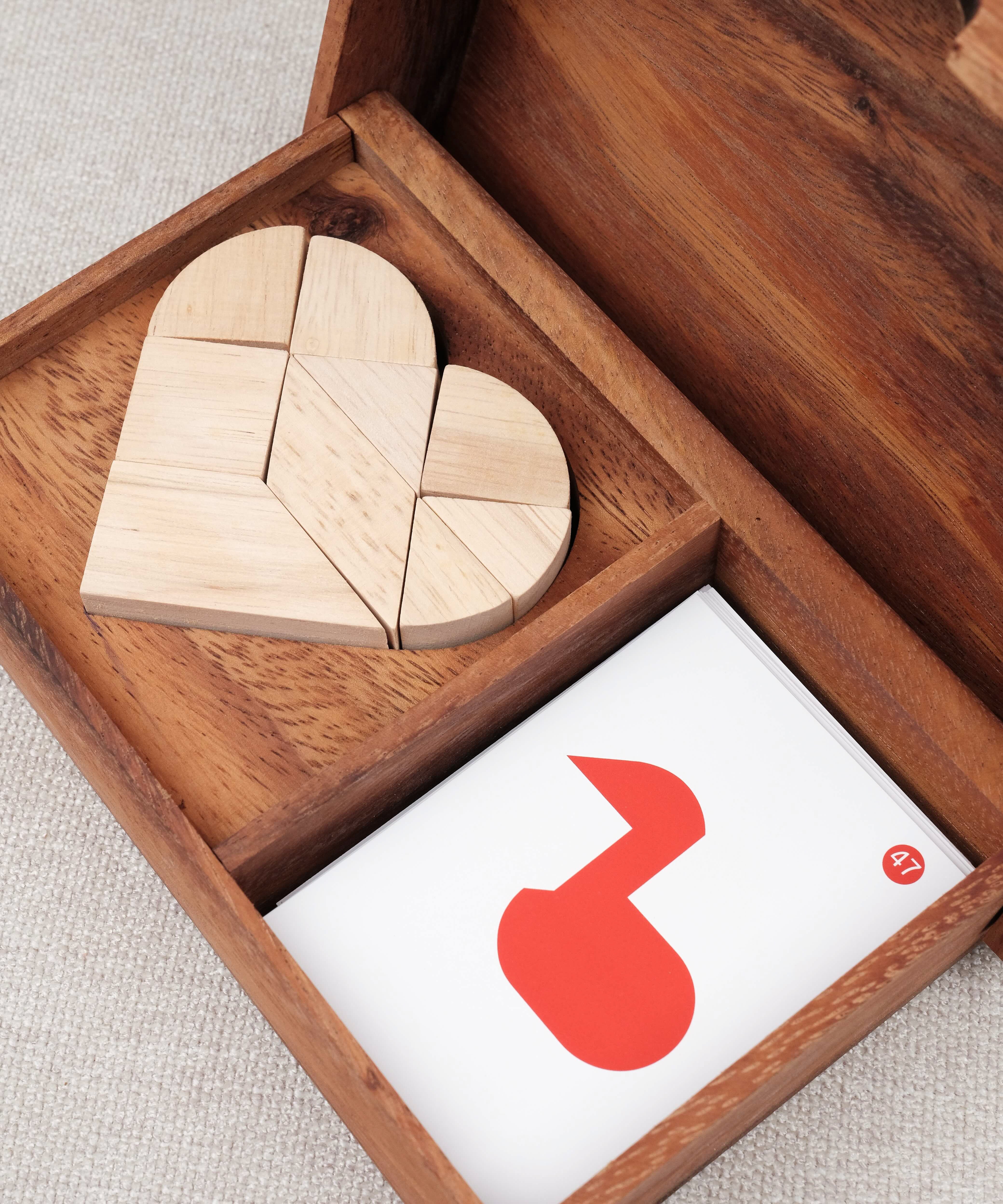Vue rapprochée du tangram cœur en bois avec cartes – Double Tangram Cœur Jeux Faugère