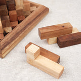 Pièces en bois de la Grande Kheops posées à côté du socle, prêtes à être assemblées.