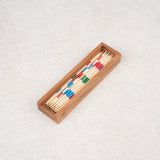 Coffret en bois d’acacia contenant un jeu de Mikado en baguettes colorées.