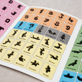 Livret ouvert avec modèles colorés de figures à reproduire – Tangram et son Livret Jeux Faugère
