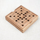 Main déplaçant un pion sur le plateau du jeu de Marelle (Moulin) en bois Jeux Faugère