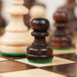 Pion d’échecs marron sur plateau en bois clair et foncé
