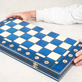 Jeu d'échecs en bois bleu grand format Jeux Faugère, plateau ouvert avec pièces en position de jeu