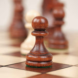 Gros plan sur un pion d’échecs marron clair sculpté en bois
