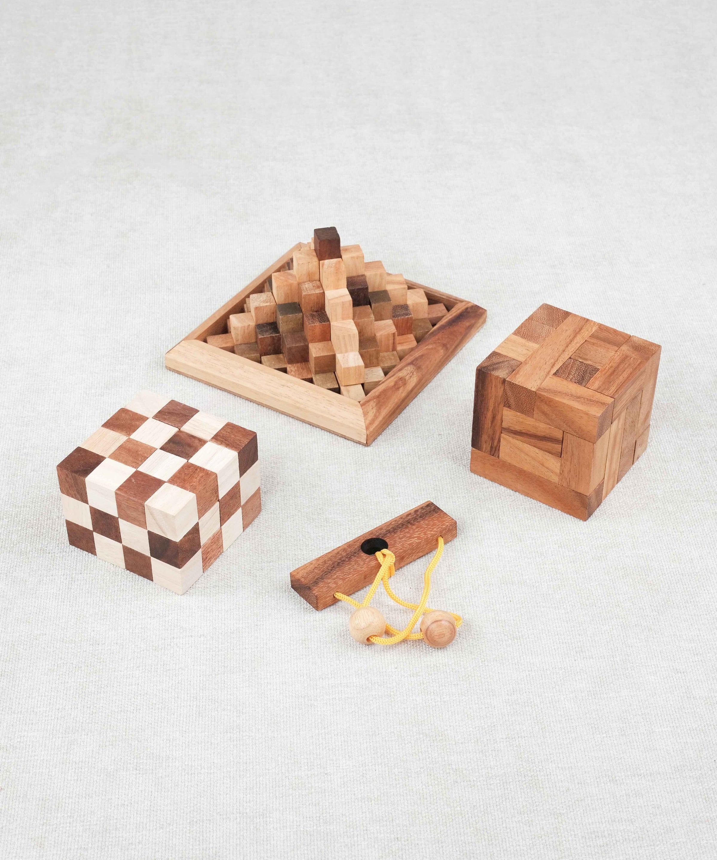 Les trois casse-têtes du pack alignés sur fond clair : Double Cube, convolution, Kheops avec le mini casse-tête offert Roméo et Juliette