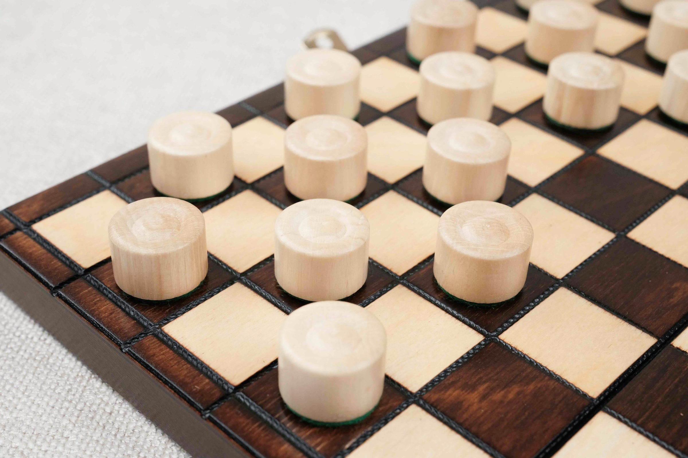 Zoom sur les pions de dames en bois clair et foncé