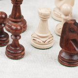 Pièces d’échecs blanche et marron clair en bois avec détails sculptés et gravés