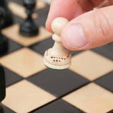 Déplacement d’un pion d’échecs blanc sur plateau en bois noir grand format