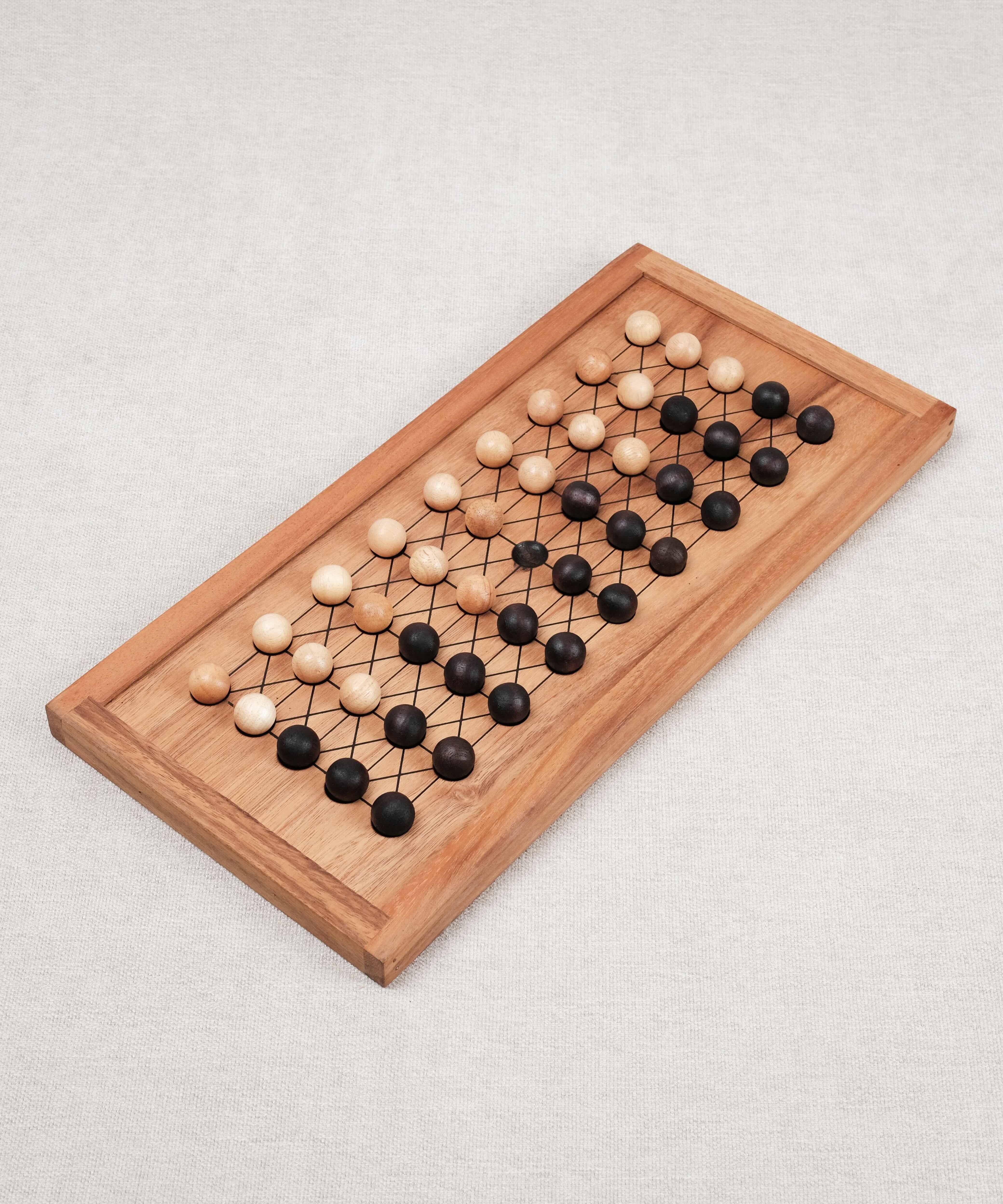 Plateau de jeu Fanorona en bois avec pions clairs et foncés alignés