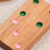 Gros plan sur une pièce de domino en bois avec points colorés