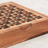 Coffret ouvert du jeu d'échecs de voyage en bois avec rangement des pièces