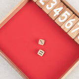 Jeu Ferme la Boîte en bois avec dés lancés sur le tapis.