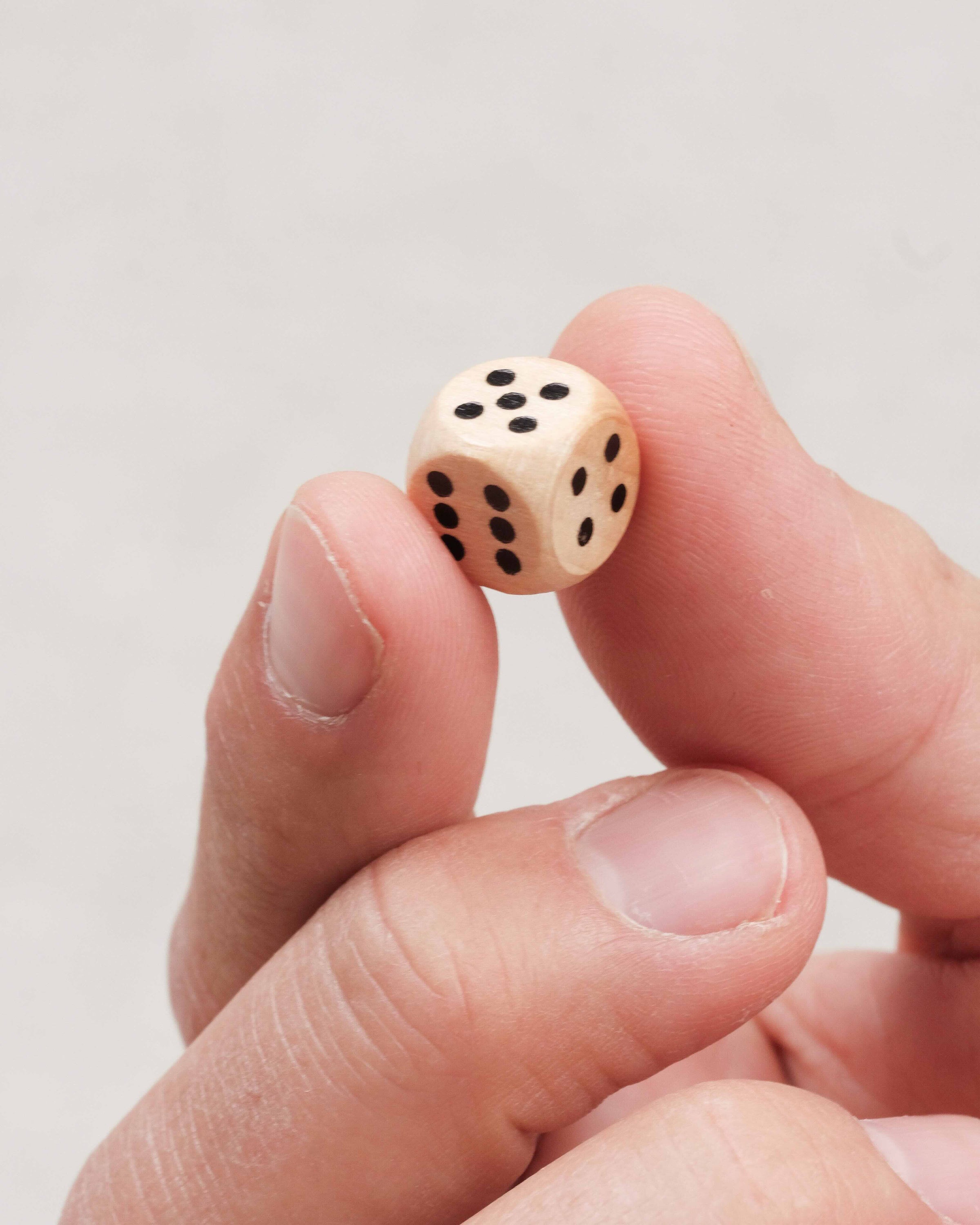 Main fermant une case numérotée du jeu Ferme la Boîte grand modèle en bois Jeux Faugère