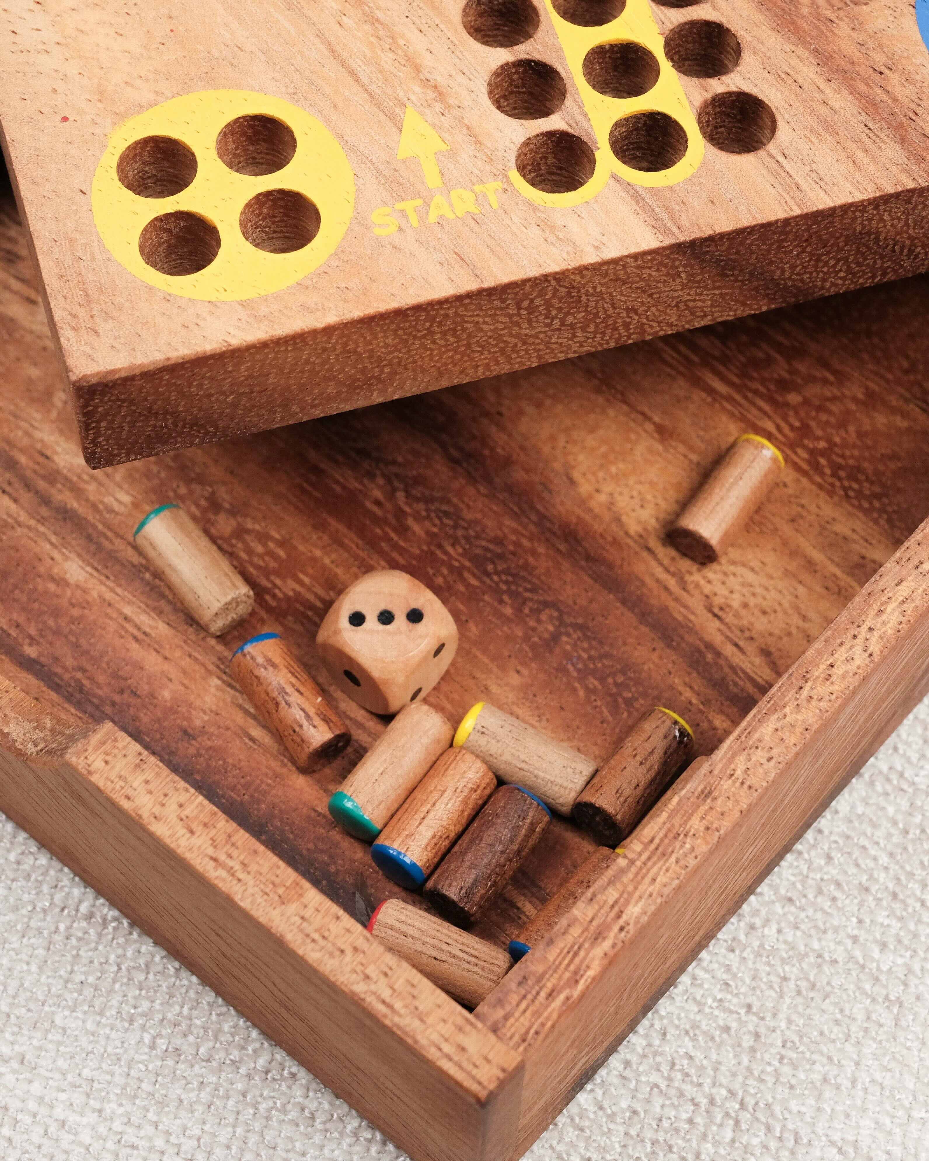Coffret en bois ouvert avec pions et rangement intégré 
