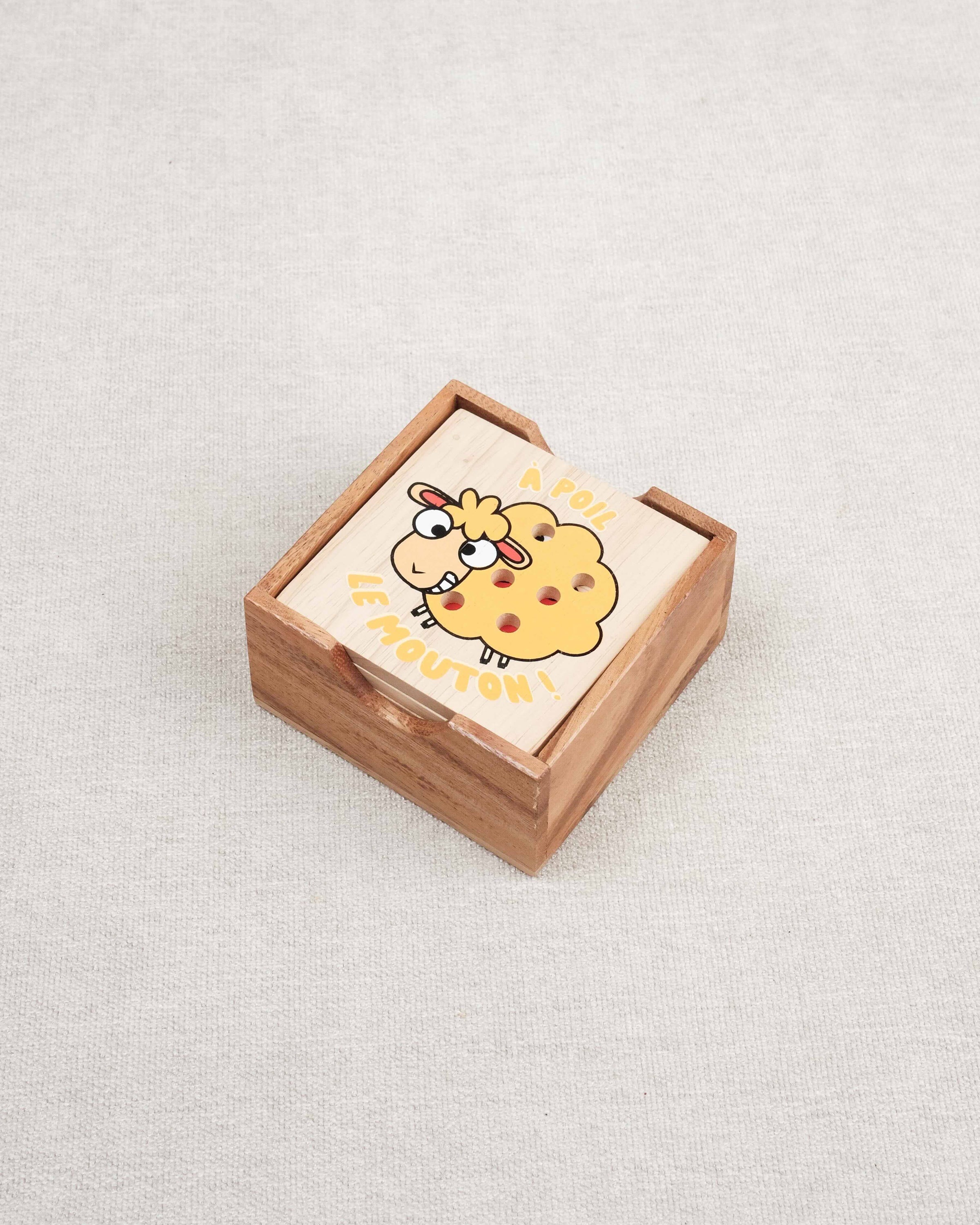Plateau en bois du jeu À Poil le Mouton avec coffret fermé et mouton jaune illustré.