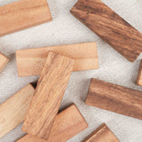 Gros plan sur les blocs de Jenga en bois massif posés en vrac su fond blanc